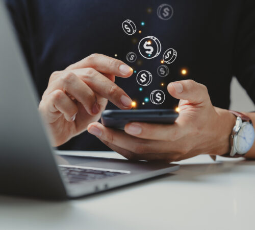 Hand of businessman using smart phone with coin icon, Online transaction, fintech business, Internet investment e-Commerce concept.